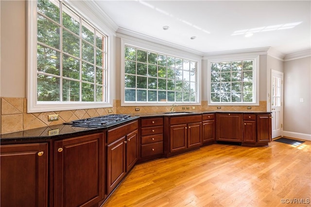 2619 Mulberry Row Rd, Midlothian, VA 23113 - kitchen with crown molding, stainless steel gas stovetop, light wood-type flooring, dark stone counters, and decorative backsplash