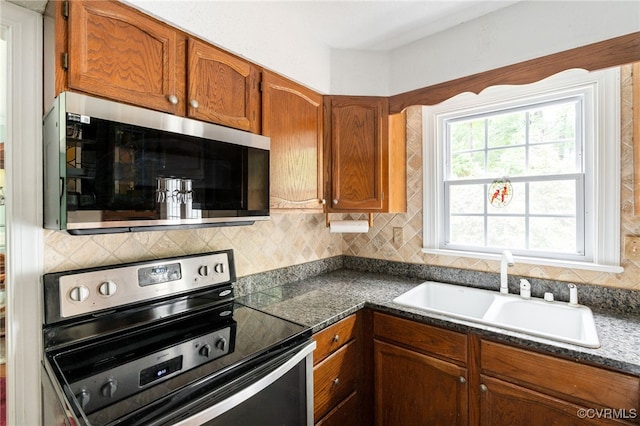 1917 Moonwind Pl, Henrico, VA 23238 - kitchen with appliances with stainless steel finishes, backsplash, brown cabinets, and dark countertops
