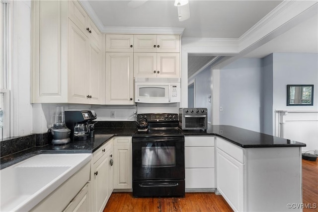 104 E 5th St, Mineral, VA 23117 - kitchen featuring black electric range, white microwave, a peninsula, crown molding, and white cabinetry