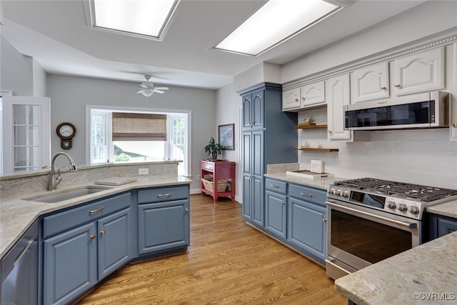 2104 Apple Grove Rd, Mineral, VA 23117 - kitchen with appliances with stainless steel finishes, blue cabinetry, light wood-style flooring, tasteful backsplash, and white cabinetry