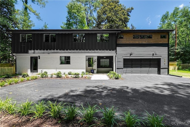 7418 Cherokee Rd, Richmond, VA 23225 - view of front of property featuring asphalt driveway, an attached garage, and board and batten siding