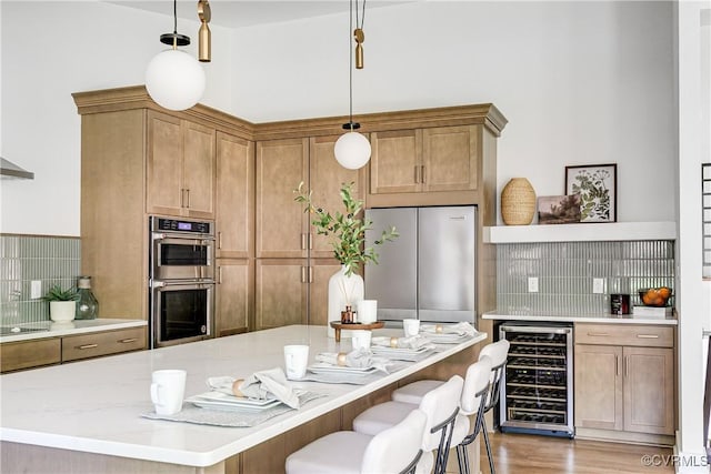 7418 Cherokee Rd, Richmond, VA 23225 - kitchen featuring beverage cooler, stainless steel appliances, hanging light fixtures, a kitchen bar, and a kitchen island