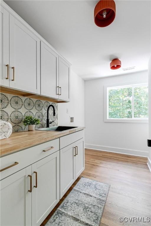 7418 Cherokee Rd, Richmond, VA 23225 - kitchen featuring light wood-style flooring, light countertops, and white cabinetry