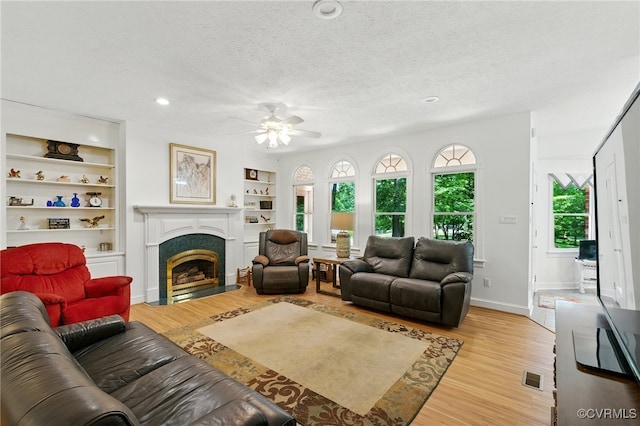 4800 Bailey Branch Ln, Quinton, VA 23141 - living room featuring a ceiling fan, light wood-style flooring, a fireplace with flush hearth, a textured ceiling, and recessed lighting