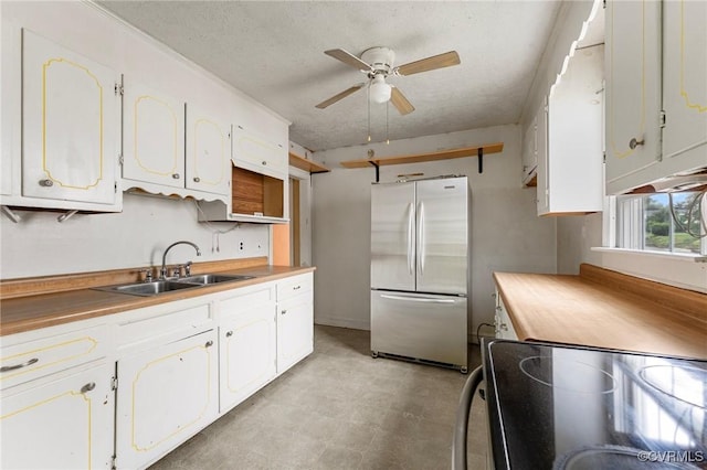 200 Hargrave Ave, Colonial Heights, VA 23834 - kitchen featuring freestanding refrigerator, black / electric stove, a ceiling fan, a textured ceiling, and white cabinets