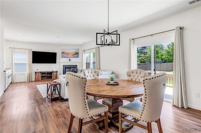 236 Central Pkwy, Aylett, VA 23009 - dining room featuring plenty of natural light, light wood finished floors, a chandelier, a glass covered fireplace, and recessed lighting