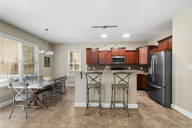 8307 Badestowe Ct, Chesterfield, VA 23832 - kitchen with stainless steel appliances, backsplash, dark brown cabinets, and decorative light fixtures