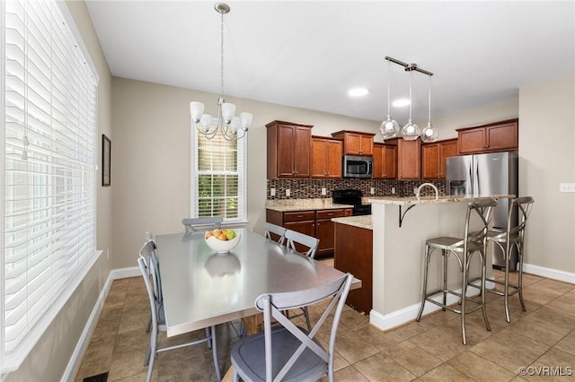 8307 Badestowe Ct, Chesterfield, VA 23832 - kitchen featuring stainless steel appliances, backsplash, a kitchen breakfast bar, decorative light fixtures, and a chandelier