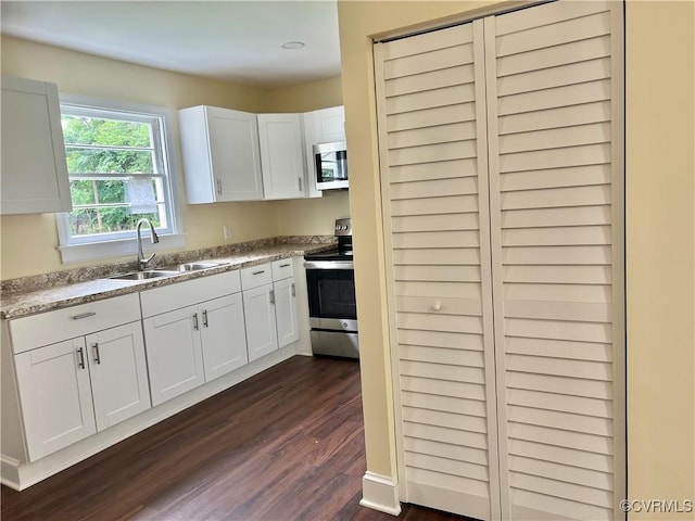 318 Youngs Rd, Petersburg, VA 23803 - kitchen with stainless steel appliances, dark wood-type flooring, white cabinets, and light countertops