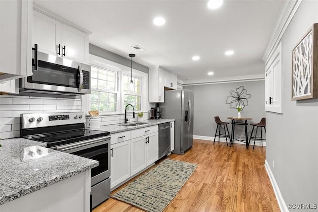 3519 Murchies Hill Rd, Richmond, VA 23234 - kitchen featuring stainless steel appliances, decorative backsplash, white cabinetry, light stone counters, and light wood-style floors