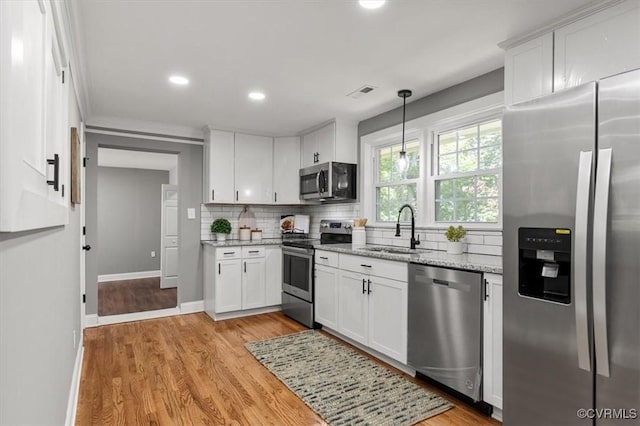 3519 Murchies Hill Rd, Richmond, VA 23234 - kitchen featuring stainless steel appliances, backsplash, white cabinets, light wood-style flooring, and recessed lighting