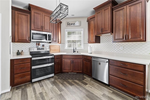2925 Mariners Pl, Midlothian, VA 23112 - kitchen featuring stainless steel appliances, dark wood finished floors, tasteful backsplash, light countertops, and pendant lighting