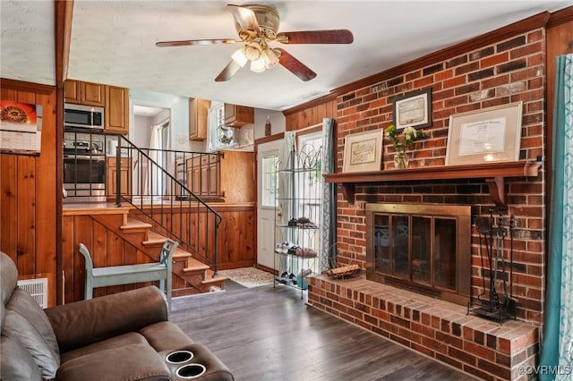 301 Perth Ln, Sandston, VA 23150 - living area featuring wood finished floors, ceiling fan, a brick fireplace, stairway, and wood walls