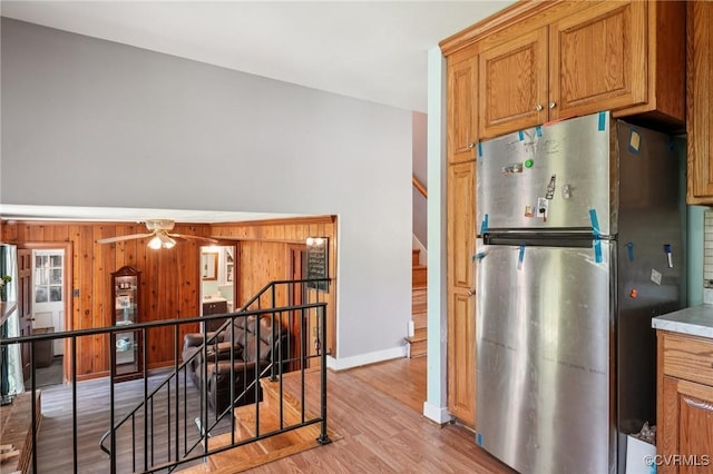 301 Perth Ln, Sandston, VA 23150 - kitchen with freestanding refrigerator, light wood-style floors, ceiling fan, wood walls, and brown cabinetry