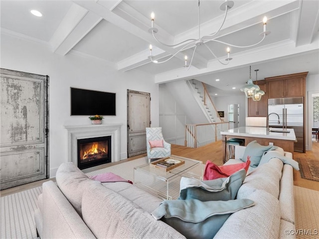 511 Libbie Ave Unit C, Richmond, VA 23226 - living room with a chandelier, light wood-type flooring, beam ceiling, stairway, and a glass covered fireplace