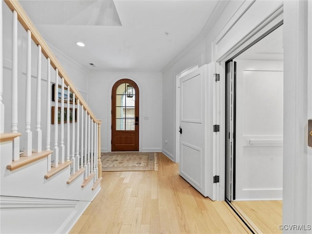 511 Libbie Ave Unit C, Richmond, VA 23226 - entrance foyer featuring light wood finished floors, crown molding, recessed lighting, arched walkways, and stairs