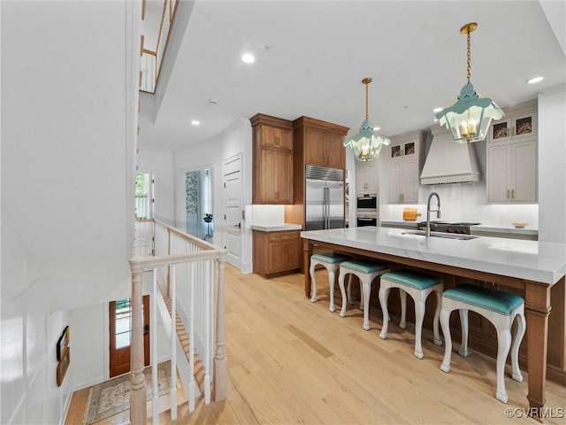 511 Libbie Ave Unit C, Richmond, VA 23226 - kitchen featuring stainless steel appliances, premium range hood, a chandelier, light wood finished floors, and light countertops