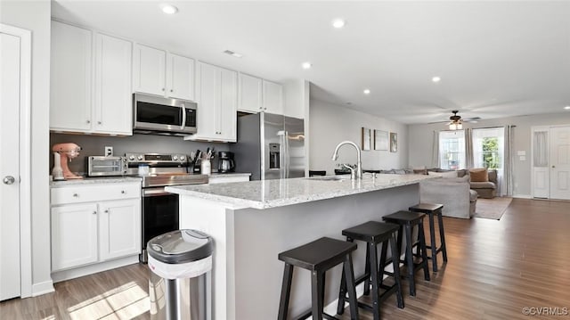 1954 Kennington Park Rd, Aylett, VA 23009 - kitchen featuring appliances with stainless steel finishes, wood finished floors, white cabinets, a center island with sink, and recessed lighting