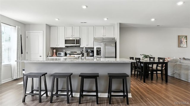 1954 Kennington Park Rd, Aylett, VA 23009 - kitchen with appliances with stainless steel finishes, an island with sink, white cabinetry, a kitchen bar, and dark wood-type flooring