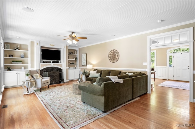 8707 Taylor Landing Pl, Chesterfield, VA 23838 - living area with crown molding, built in features, ceiling fan, light wood-style floors, and wainscoting