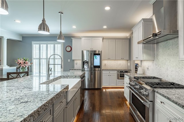 2449 Gold Leaf Cir, Henrico, VA 23233 - kitchen featuring wall chimney exhaust hood, appliances with stainless steel finishes, decorative columns, dark wood-type flooring, and backsplash