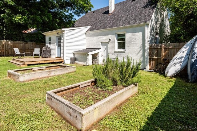 3712 Moody Ave, Richmond, VA 23225 - back of property featuring a vegetable garden, a chimney, a deck, roof with shingles, and brick siding