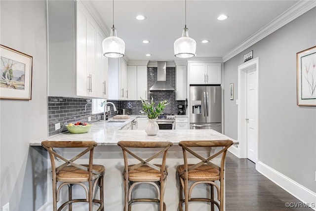 5005 Caledonia Rd, Richmond, VA 23225 - kitchen with stainless steel appliances, wall chimney range hood, a peninsula, decorative backsplash, and recessed lighting