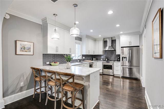 5005 Caledonia Rd, Richmond, VA 23225 - kitchen with stainless steel appliances, wall chimney range hood, a peninsula, crown molding, and decorative backsplash
