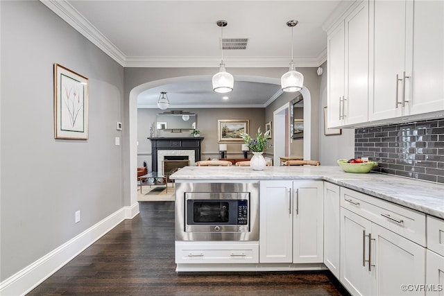 5005 Caledonia Rd, Richmond, VA 23225 - kitchen featuring stainless steel microwave, arched walkways, dark wood-style flooring, a peninsula, and white cabinets