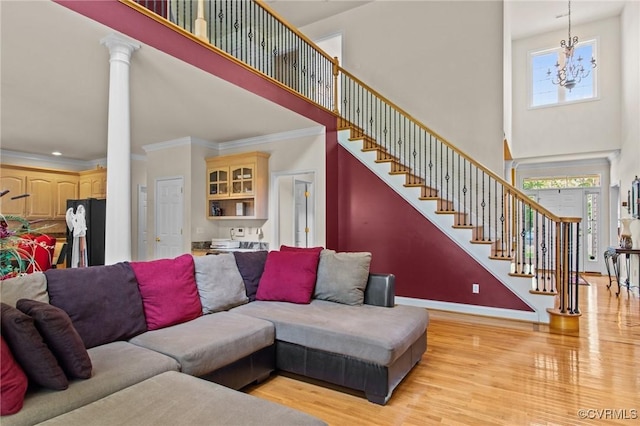 301 Enon Oaks Ln, Chesterfield, VA 23836 - living room featuring a towering ceiling, healthy amount of natural light, light wood-style floors, ornamental molding, and stairway