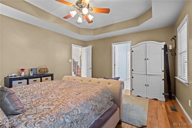 301 Enon Oaks Ln, Chesterfield, VA 23836 - bedroom featuring light wood-type flooring, a tray ceiling, and ceiling fan