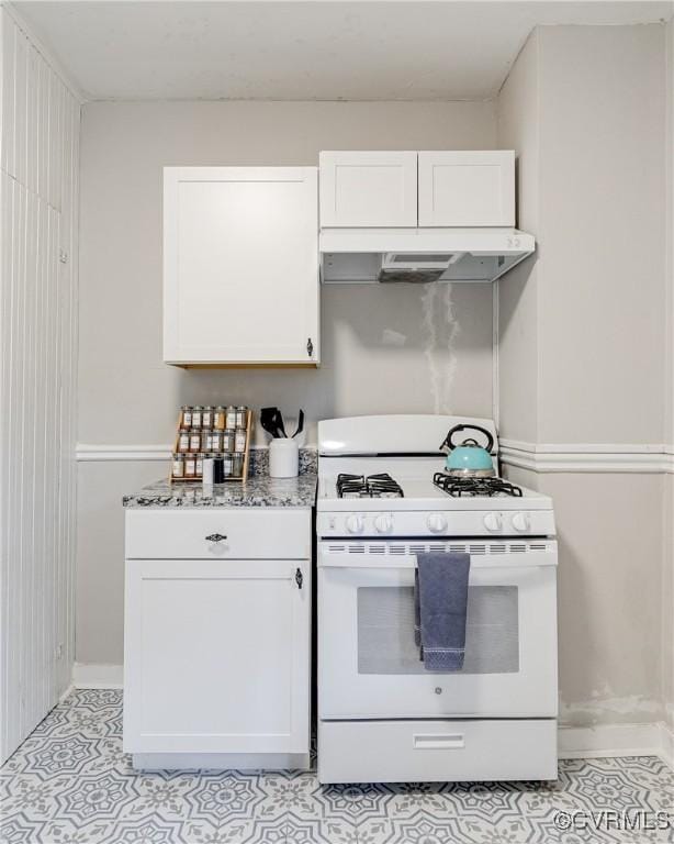 4302 W Franklin St, Richmond, VA 23221 - kitchen featuring white gas range oven, premium range hood, white cabinetry, and light tile patterned flooring