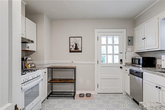 4302 W Franklin St, Richmond, VA 23221 - kitchen with appliances with stainless steel finishes, under cabinet range hood, white cabinetry, light stone counters, and light tile patterned floors