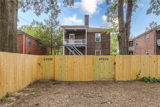 4302 W Franklin St, Richmond, VA 23221 - back of house featuring a fenced backyard, brick siding, a chimney, and a gate