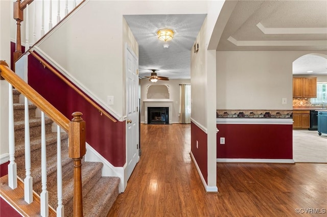 135 Hobbs Hole Ln, Tappahannock, VA 22560 - foyer entrance with arched walkways, a ceiling fan, wood finished floors, a fireplace, and stairs
