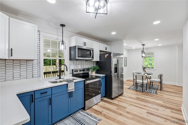 5318 Pine Hill Rd, Sutherland, VA 23885 - kitchen featuring appliances with stainless steel finishes, light wood-style floors, decorative backsplash, white cabinetry, and blue cabinetry