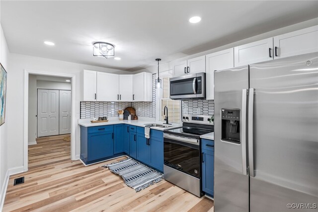 5318 Pine Hill Rd, Sutherland, VA 23885 - kitchen featuring stainless steel appliances, blue cabinetry, light countertops, white cabinetry, and light wood-style flooring