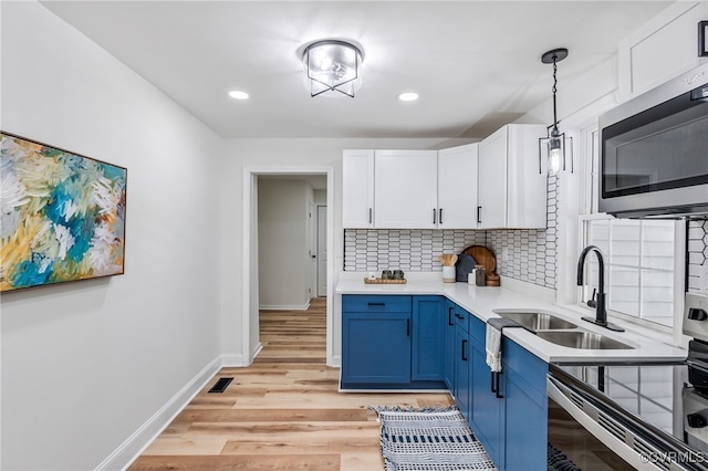 5318 Pine Hill Rd, Sutherland, VA 23885 - kitchen featuring stainless steel appliances, blue cabinetry, backsplash, light countertops, and white cabinetry