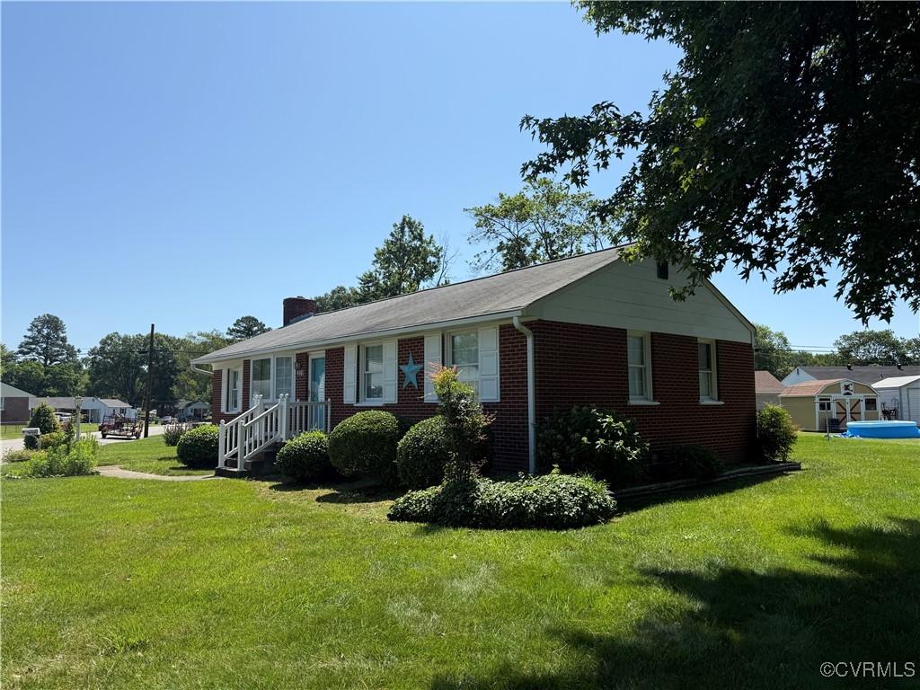 4901 Clayton Rd, Henrico, VA 23231 - view of front of house with a front yard, brick siding, and a chimney