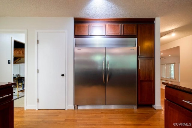 12931 River Hills Dr, Richmond, VA 23111 - kitchen featuring built in refrigerator, light wood finished floors, a textured ceiling, and dark stone countertops