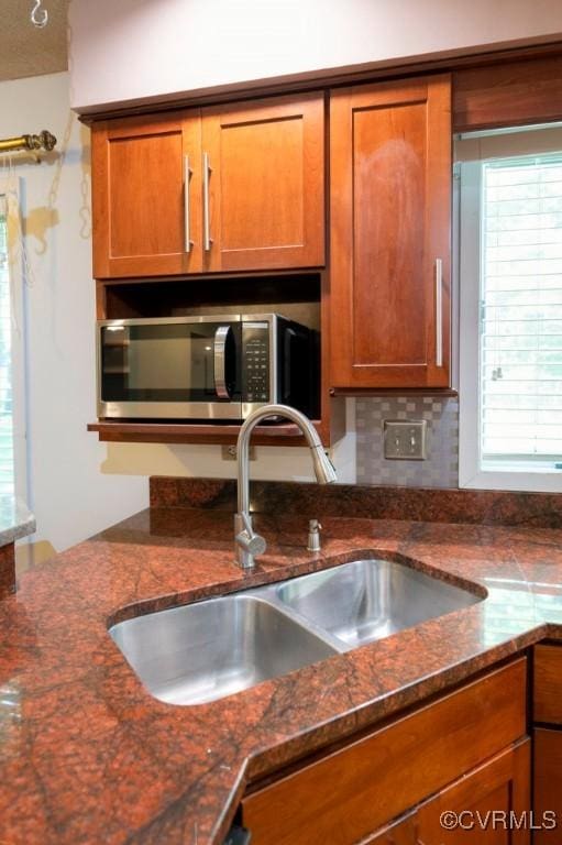 12931 River Hills Dr, Richmond, VA 23111 - kitchen with stainless steel microwave, brown cabinets, dark stone counters, and tasteful backsplash