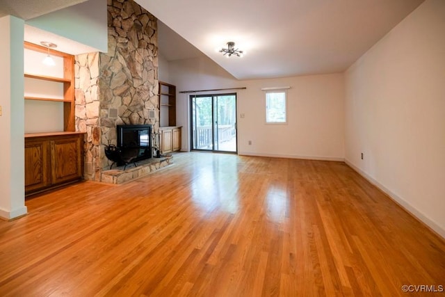 12931 River Hills Dr, Richmond, VA 23111 - unfurnished living room featuring light wood-style flooring, lofted ceiling, a stone fireplace, and built in shelves