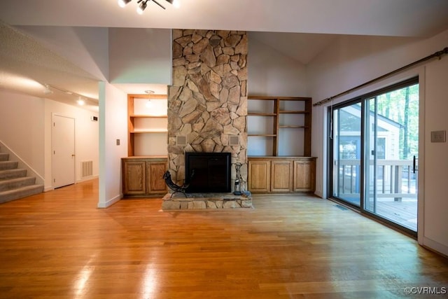 12931 River Hills Dr, Richmond, VA 23111 - unfurnished living room featuring light wood finished floors, stairs, a fireplace, track lighting, and built in features