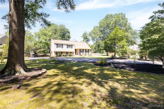 9201 Claymont Dr, Henrico, VA 23229 - view of front of home featuring a front yard, a detached carport, and a chimney