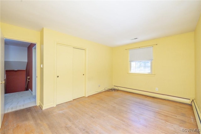 9201 Claymont Dr, Henrico, VA 23229 - unfurnished bedroom with a baseboard heating unit, light wood-style floors, and a closet