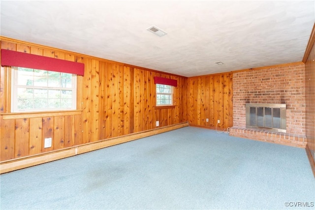 9201 Claymont Dr, Henrico, VA 23229 - unfurnished living room with a baseboard heating unit, carpet floors, wood walls, and a brick fireplace