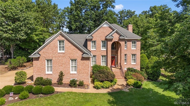 3105 Sapling Dr, Toano, VA 23168 - view of front of house with brick siding, a chimney, and a front lawn