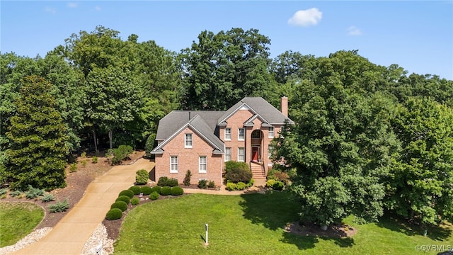 3105 Sapling Dr, Toano, VA 23168 - view of front of home featuring a front lawn, a chimney, concrete driveway, and brick siding