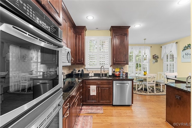 3105 Sapling Dr, Toano, VA 23168 - kitchen featuring appliances with stainless steel finishes, light wood-style flooring, backsplash, dark stone countertops, and recessed lighting