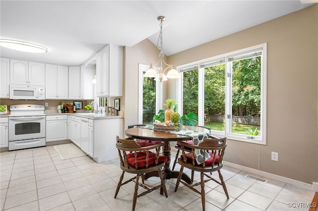 9154 Jump Cir, Mechanicsville, VA 23116 - dining area featuring light tile patterned flooring, vaulted ceiling, and a chandelier